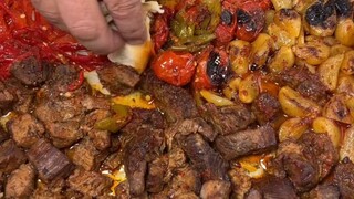 Daging panggang ala Turki dalam wajan besar, disantap dengan roti naan, plus tomat dan cabai.