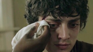 A curly-haired puppy with PTSD/shivering/big eyes full of fear and anxiety/crying silently/afraid to
