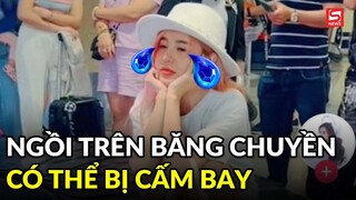 Cô gái ngồi trên băng chuyền hành lý tại sân bay có thể bị cấm bay