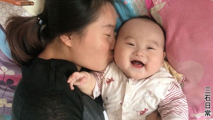 Mom forcefully kisses her 5-month-old baby, who giggles with delight—Dad can only watch helplessly a