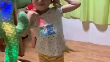 My baby dancing with her cactus toy.