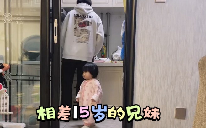 Kakak dan adik yang beda usia 15 tahun: si adik menunggu untuk diberi makan.