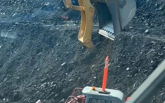 Xe xúc khổng lồ đặt thanh cảnh báo trên đầu xe ủi.