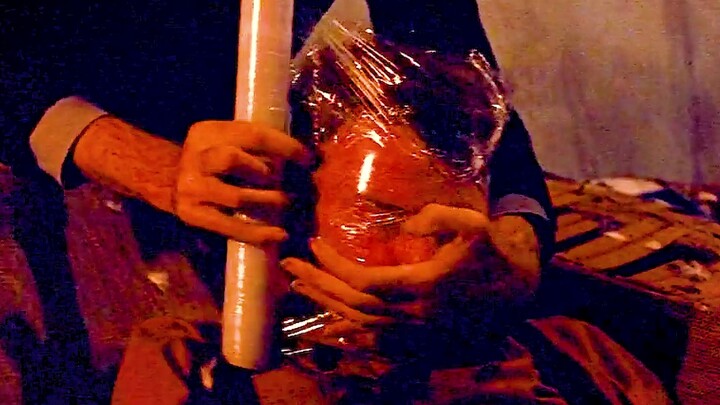 The man found something interesting and wrapped the kitten in plastic wrap.