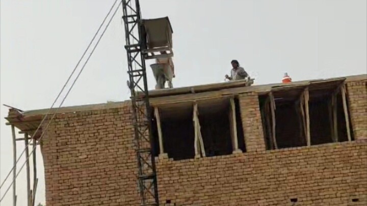 WORKERS FILLING ROOF WITH MACHINE AND HARD WORK