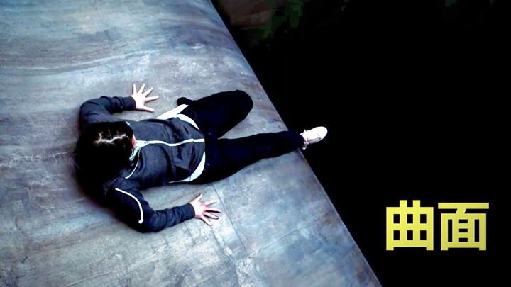 A girl is trapped on a smooth curved surface, with a sheer abyss beneath her feet—pure suspense.