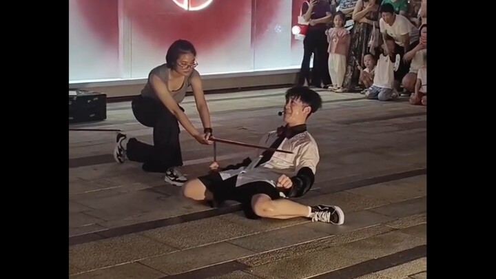 A guy clears the pole while listening to some tunes! Street performing is no walk in the park!