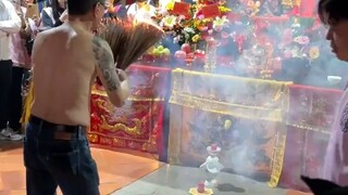 祈福男子抓着点燃的香，往身上均匀的涂抹