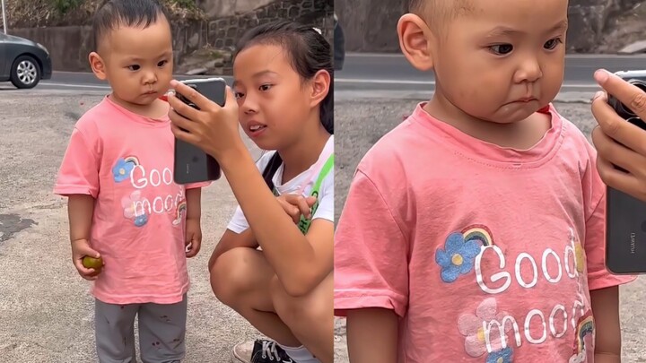 Bayi menatap ayah dan ibunya lewat layar ponsel, wajahnya tampak sedih seolah ingin menangis namun i