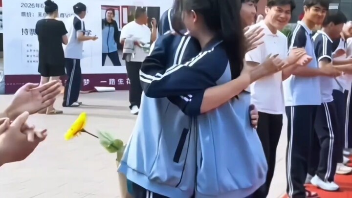 Sebelum meninggalkan sekolah, seorang siswi memeluk sahabatnya; pelukan itu benar‑benar menjadi sala