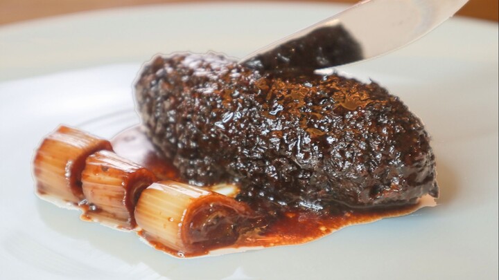 A course of braised sea cucumber with scallion