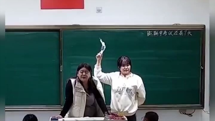 Guru mengajar sambil mendapat infus, sedangkan wali kelas membantu berperan sebagai “rak infus”.