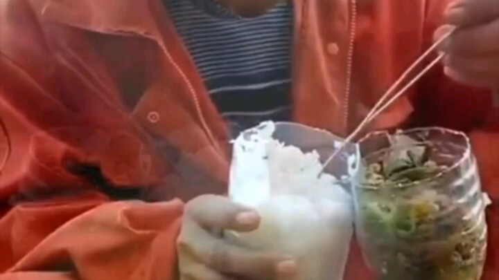 Workers eat at the construction site: rice under the bottle, pickles on top—cut it open when you’re 