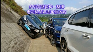 There was a whole row of cars stuck in a narrow rural road. An experienced driver climbed over the w