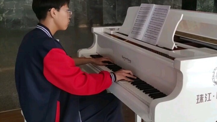 เล่น "ฐานลับ" บนเปียโนในห้องโถงของโรงเรียน