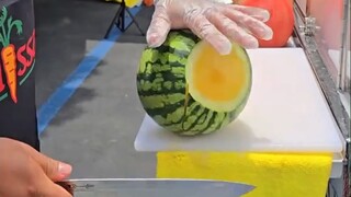 The fruit vendor peels the watermelon, and his knife skills are very pleasant to watch...