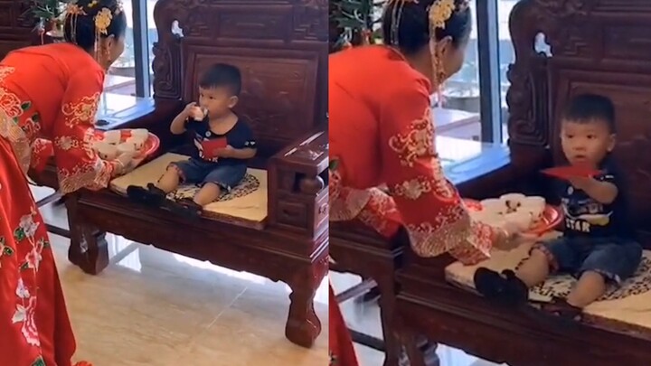 العروس تقدّم الشاي لدمية أكبر منها في المرتبة، والطفل اللطيف يشرب بوجه حائر تمامًا، بينما إطلالته ال