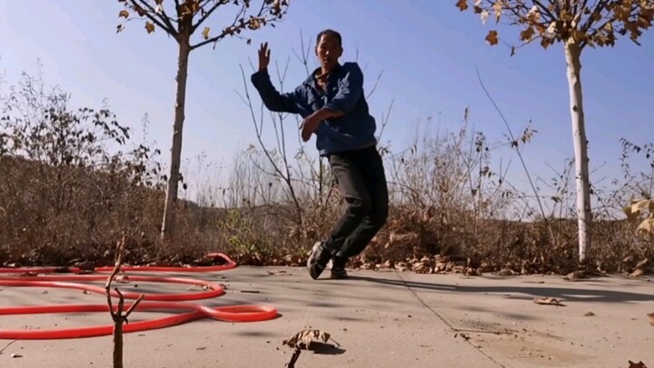 The old man in the countryside was interested in watering the trees, so he put down the water pipe a