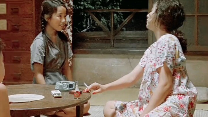 The girl reaches out to take the pocket money her mom gives her, but her mother presses a cigarette 