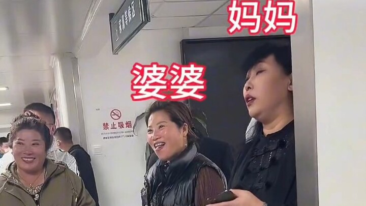 Outside the delivery room, the mother stands out as an oddity amid the bustling crowd.