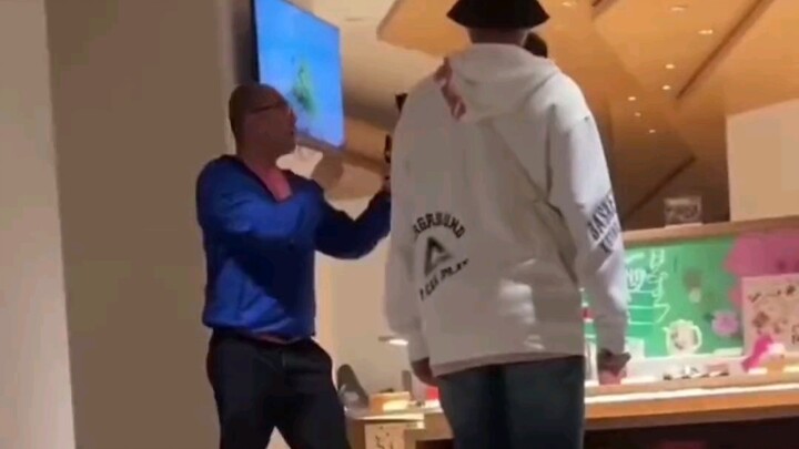 In a Shanghai shopping mall, a foreign man shoved and pushed away a Chinese man.