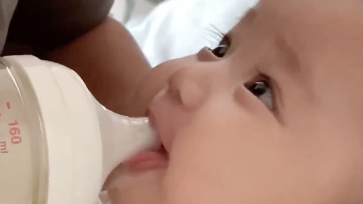 The baby’s loving gaze while being fed—truly the dad’s little warm companion!