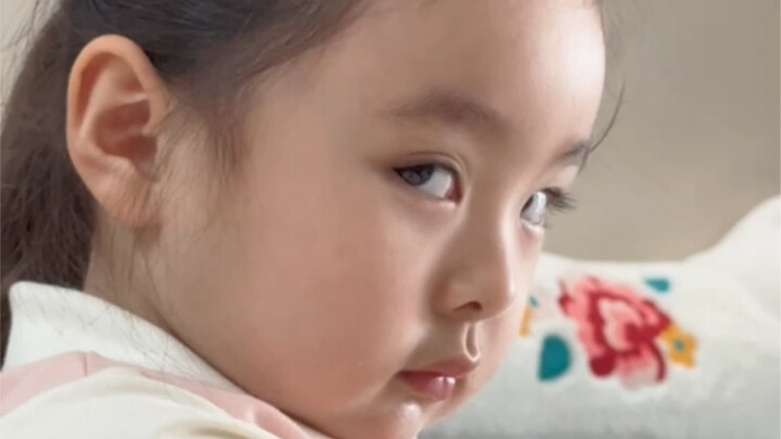Cute kid eats watermelon, watching mom take a spoonful right before their eyes, their expression gra