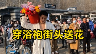 Wearing a bathrobe and giving flowers to strangers on the street