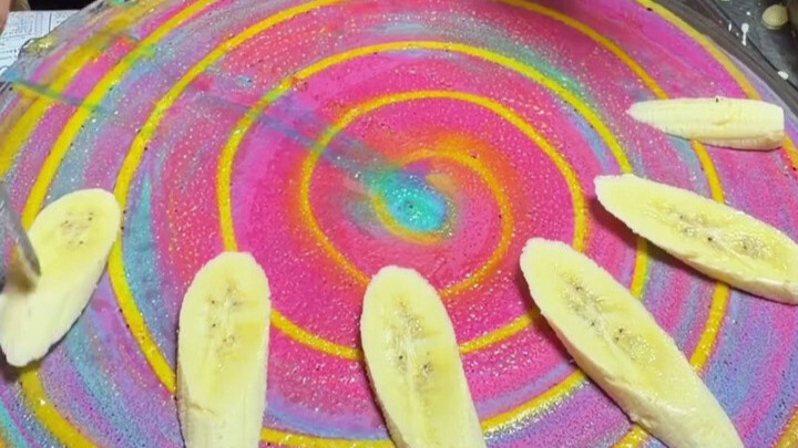 Kreasi pancake pisang raksasa berbentuk cacing di jalanan Bangkok—begitu cacing besar ditaruh di ata