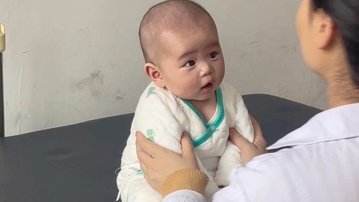 Petugas pemeriksa kualitas bayi manusia sedang memeriksa barang, kepala mungil dengan seribu satu ta