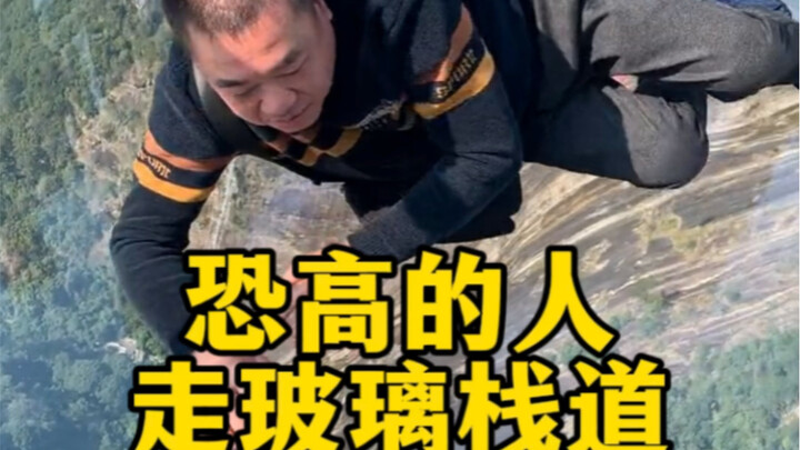 People afraid of heights walk on the glass skywalk.