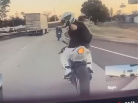 اندفعوا ليُظهِروا الإبهام، والدراجة النارية تُحرَق في لهيب الحريق.