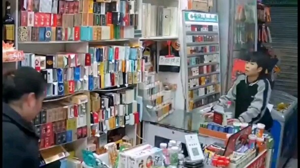 Young guy snatches a “cigarette” while the supermarket boss isn’t looking and bolts—boss stays calm 