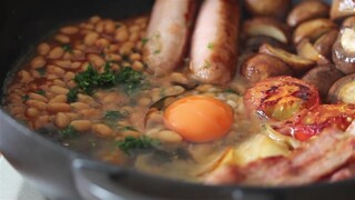 Seperiuk penuh sarapan Inggris yang lezat, telur, sosis, bacon, dan lainnya, disajikan bersama secan