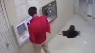 A strange, jet-black liquid suddenly spurted out from the ground beneath the ATM, startling the man,