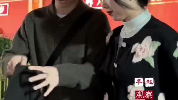 A couple poses for a souvenir photo in front of Tiananmen Square. The guy is dashing and handsome, w