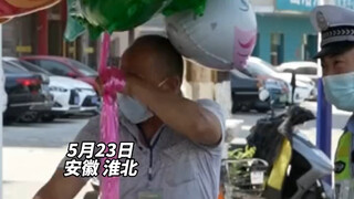 An elderly man riding a bike while holding a balloon in one hand was stopped and lectured by traffic