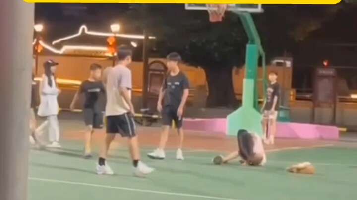 On the basketball court, a man kicks a woman’s keys away, leaving her caught off guard and knocked d