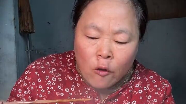 See how happy a rural mother is after a day of farm work, eating scrambled eggs with onions and shre