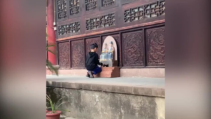 The little boy burns incense and trades it to the Earth God for a lollipop. The Earth God says, “You