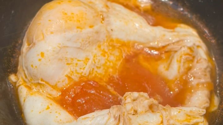 สาวน้อยกำลังตรวจสอบระดับความสุกของไข่ต้มในหม้อไฟอันหนึ่ง