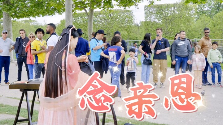 Under the Eiffel Tower, a guzheng passionately performs "Remembering Parental Grace," with all longi