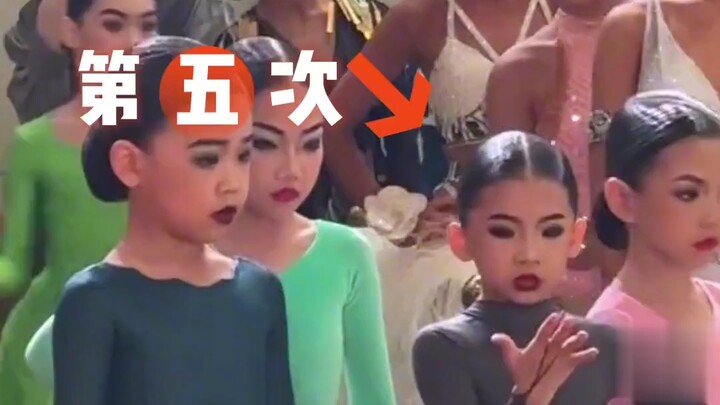 在某拉丁舞比赛现场，主持人宣布进入决赛的选手名单时，一位女孩频频看号码，确认是否点到自己，可爱极了