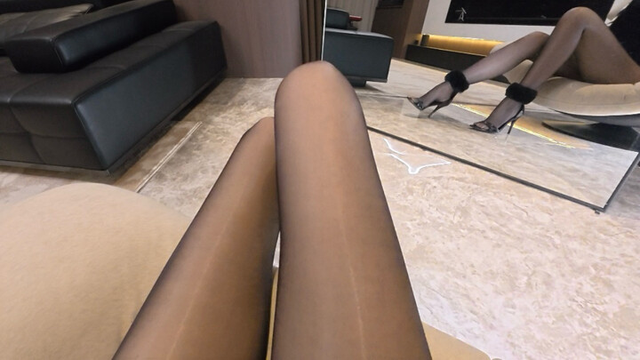 Rekaman proses berpakaian all‑black dengan stoking hitam mengilap dan mantel bulu hitam dalam pengal