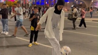 Seorang gadis memamerkan keahliannya dengan seorang penggemar pria asing di luar stadion Piala Dunia