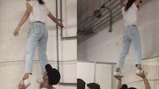Một cậu bé nhấc quả bóng rổ do một cô gái cầm trên ống nước lên, nhưng quả bóng lăn sang phía bên ki