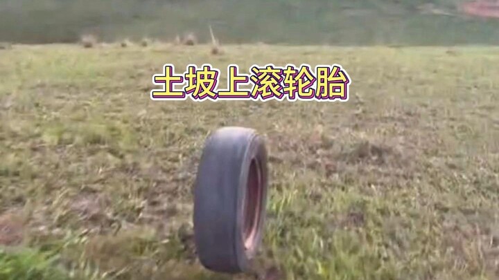 A boy's happiness is just this simple! Rolling a tire down a dirt slope is still so stress-relieving