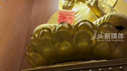 วันที่ 5 เมษายน ที่หนานจิง มณฑลเจียงซู หญิงสาวไปเที่ยวชมวัด พบว่าพระพุทธรูปถือลูกอมรสส้ม QQ อยู่ในมื