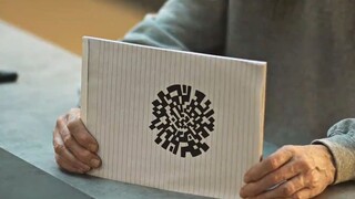男人手绘了一个圆形二维码，将二维码对准囚室上的摄像头《玩物》