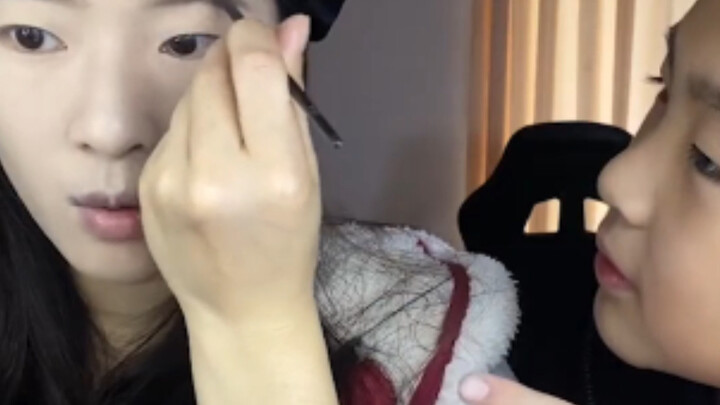 Little brother has tons of questions about his sister’s makeup!